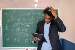 A teacher in a classroom solving math problems on a chalkboard, illustrating education and learning.